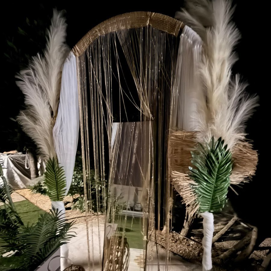 Arco boho de macramé con pampas y velas iluminado de noche en la finca Knattur
