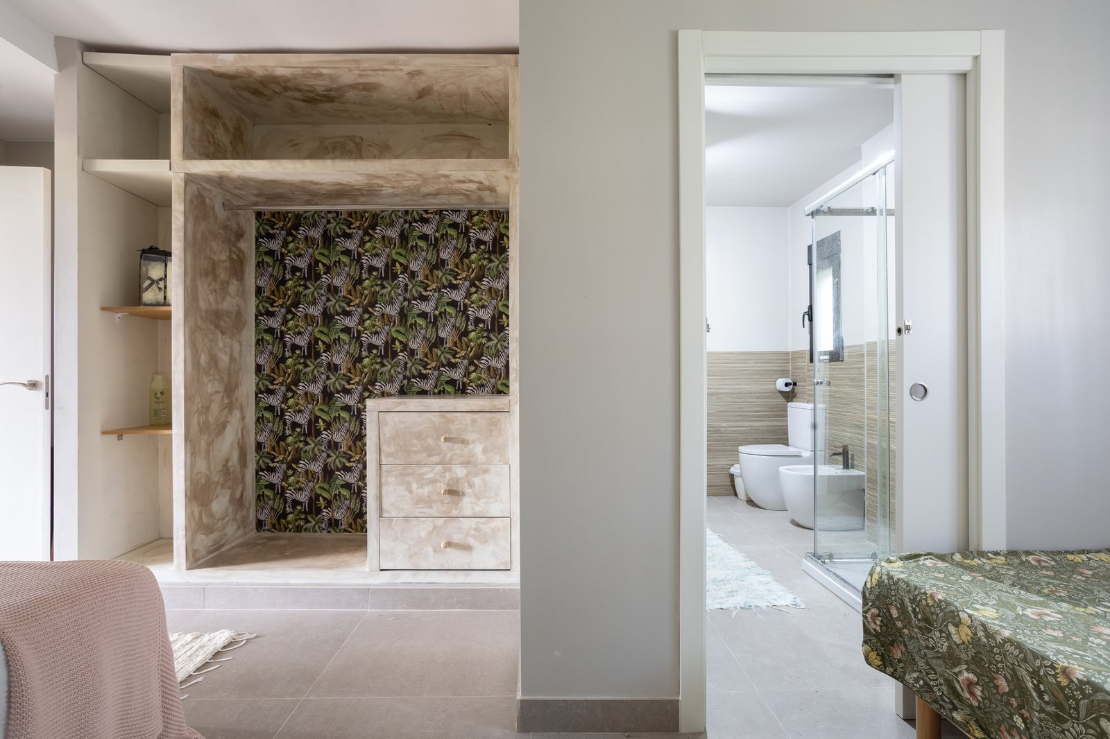 Vestidor del apartamento Bahía con papel pintado tropical y baño al fondo