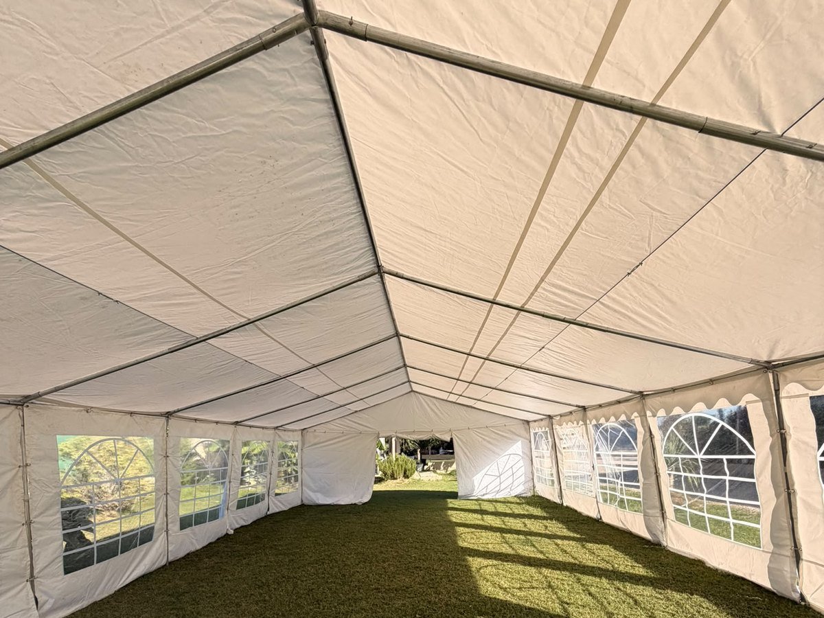 Interior de la carpa blanca montada sobre el césped del jardín de Knattur