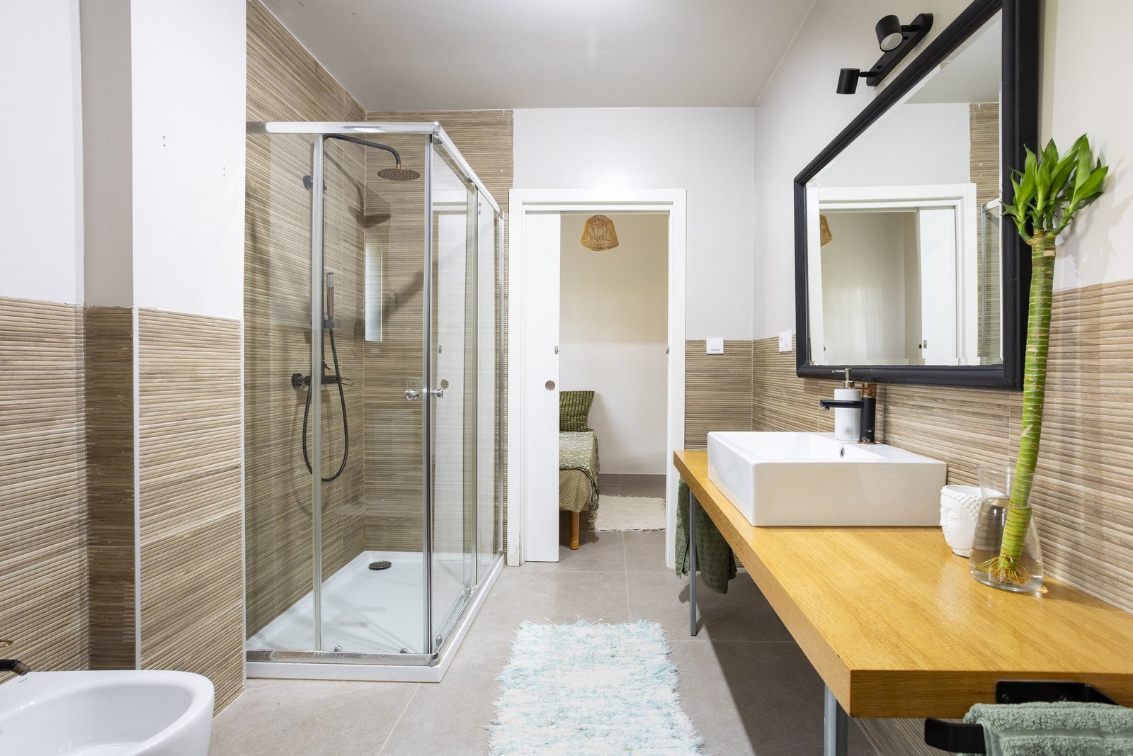 Baño con acabados en mármol y madera natural en un apartamento