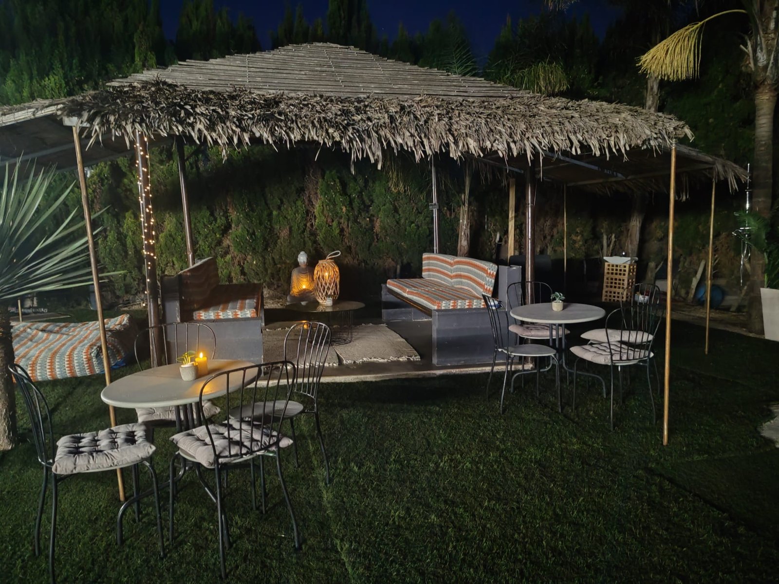 Figura de Buda dorado en la zona chill-out bajo palapa de cañizo
