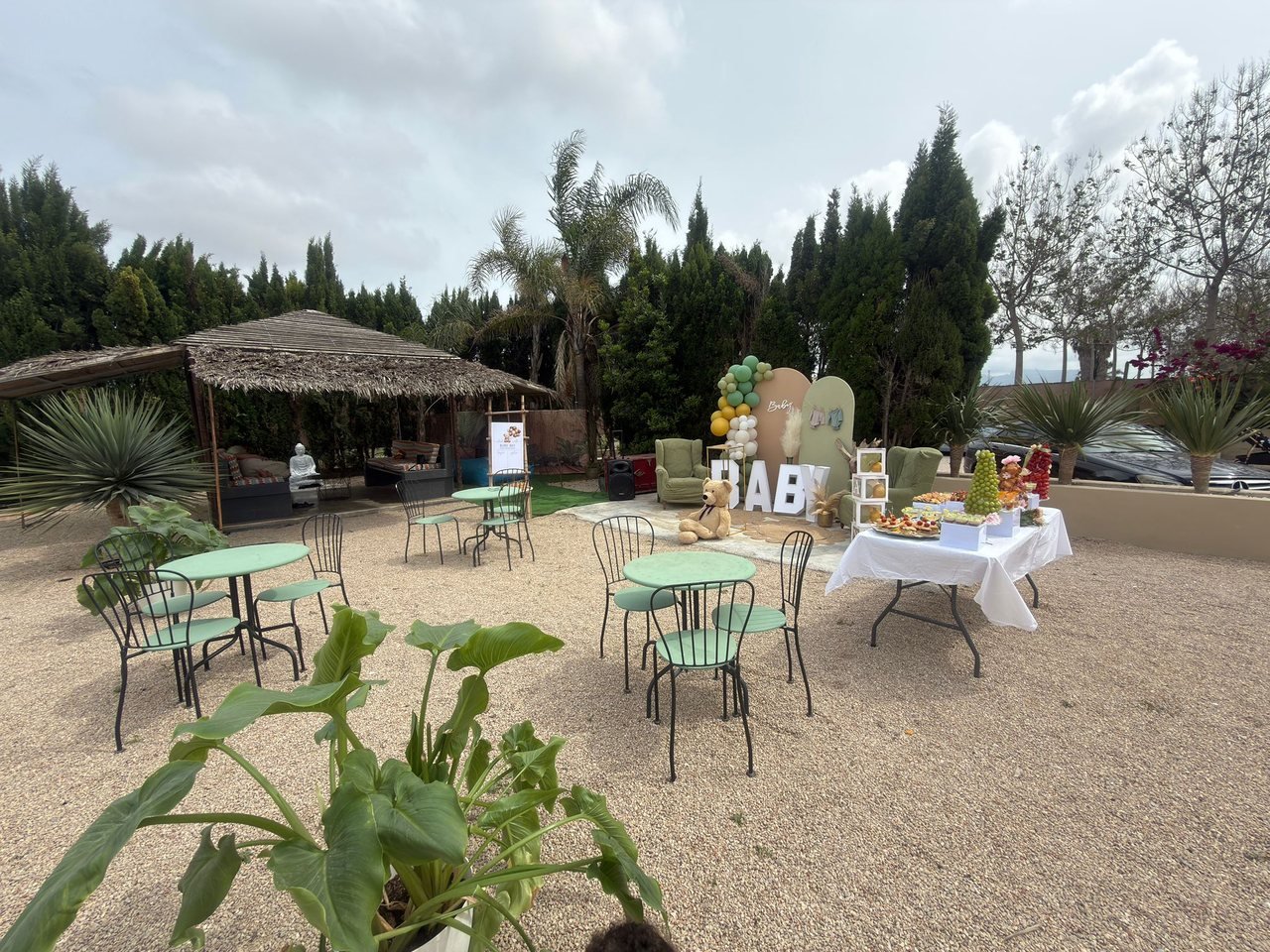 Jardín montado con mesas y decoración para una celebración al aire libre